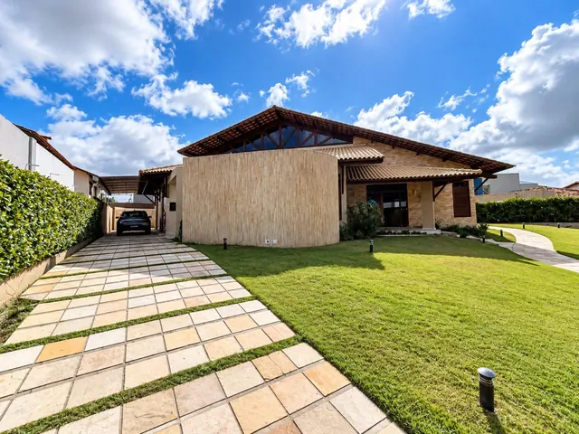 Fachada com amplo jardim e garagem lateral