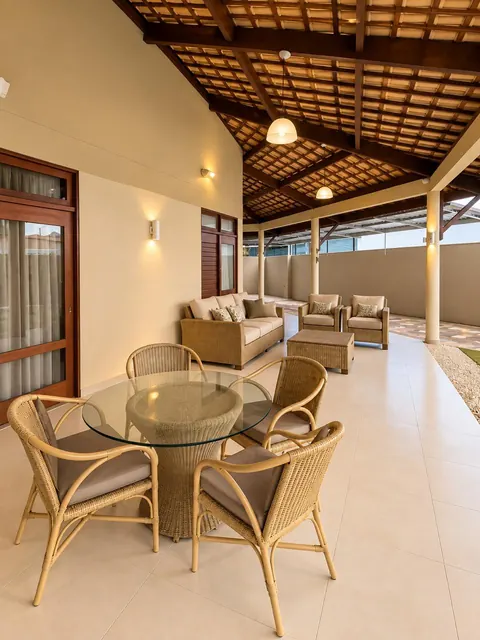 Varanda coberta com mesa e área de estar