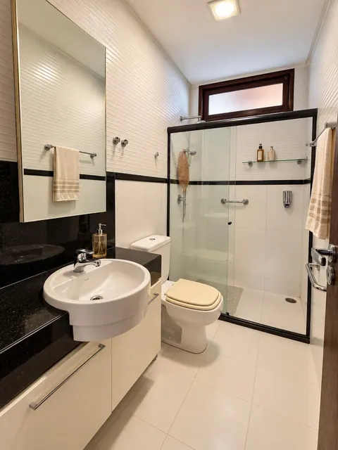 Banheiro com bancada e box de vidro