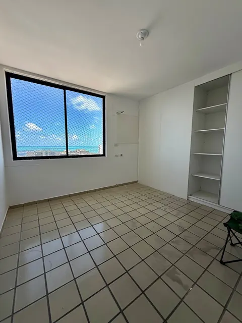 Quarto com estante embutida e vista para o mar