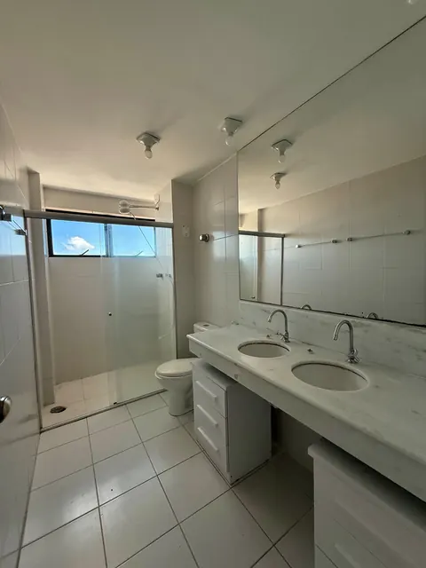 Banheiro com duas cubas e box de vidro