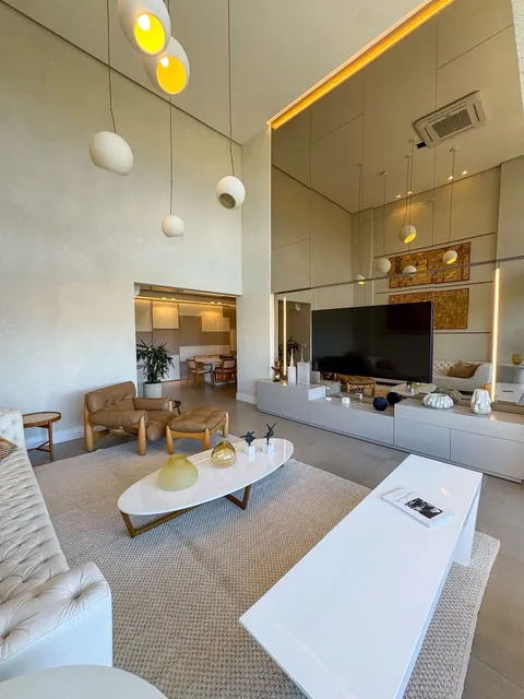 Sala de estar com painel espelhado e home theater