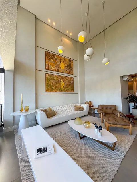 Sala de estar com obras de arte e iluminação pendente