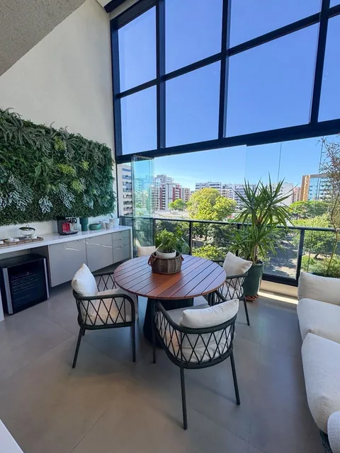 Varanda com jardim vertical e mesa de refeições