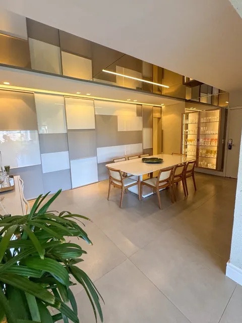 Sala de jantar com painel e cristaleira iluminada